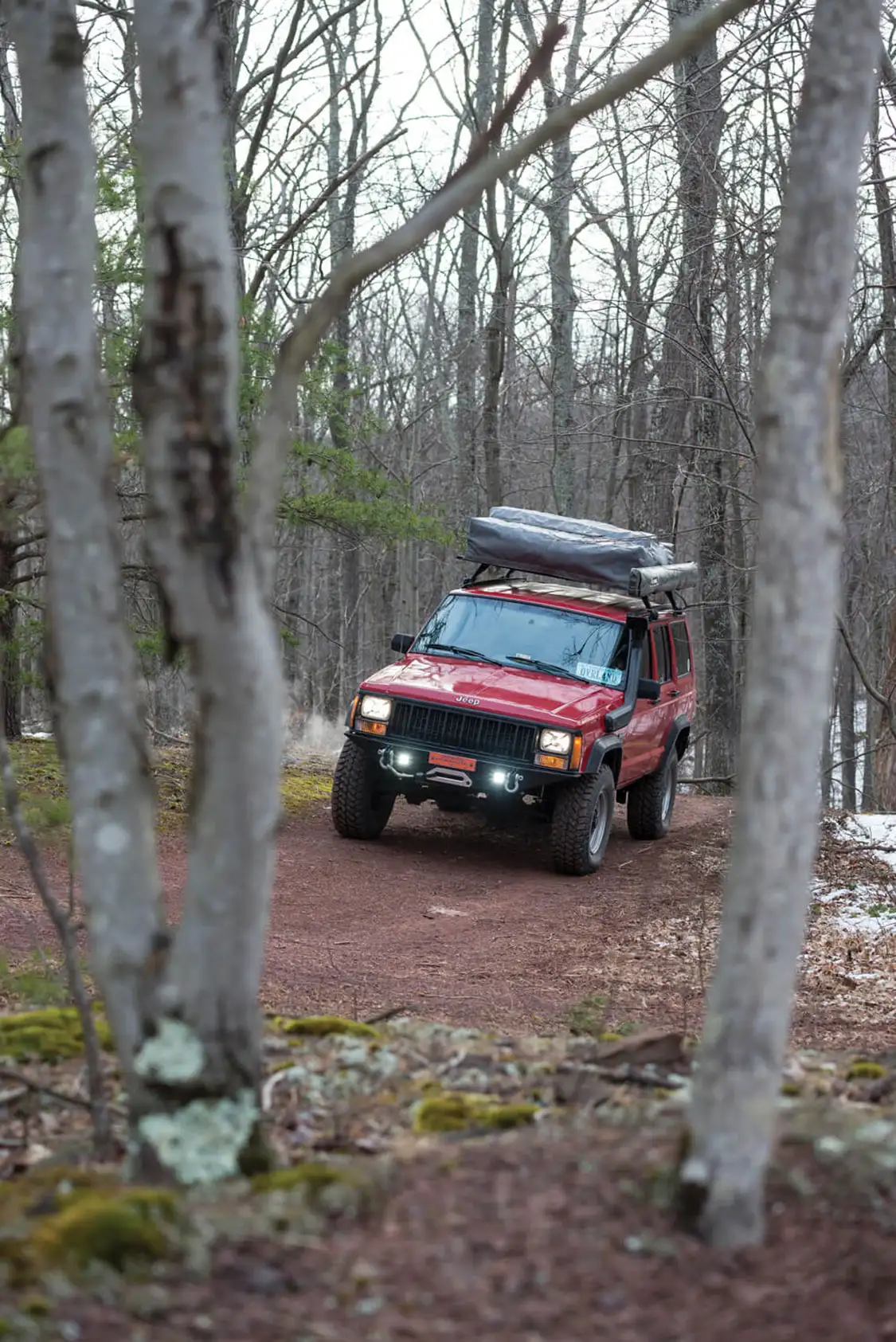 1994 Jeep Grand Cherokee XJ driving in the woods with an RTT