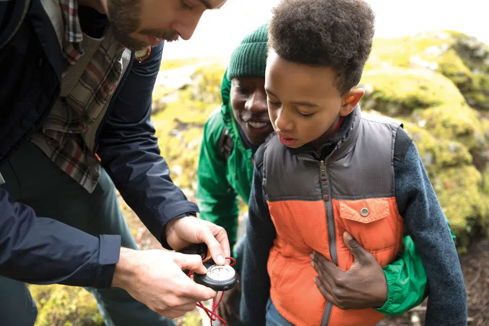 Man showing a child how to use a compass