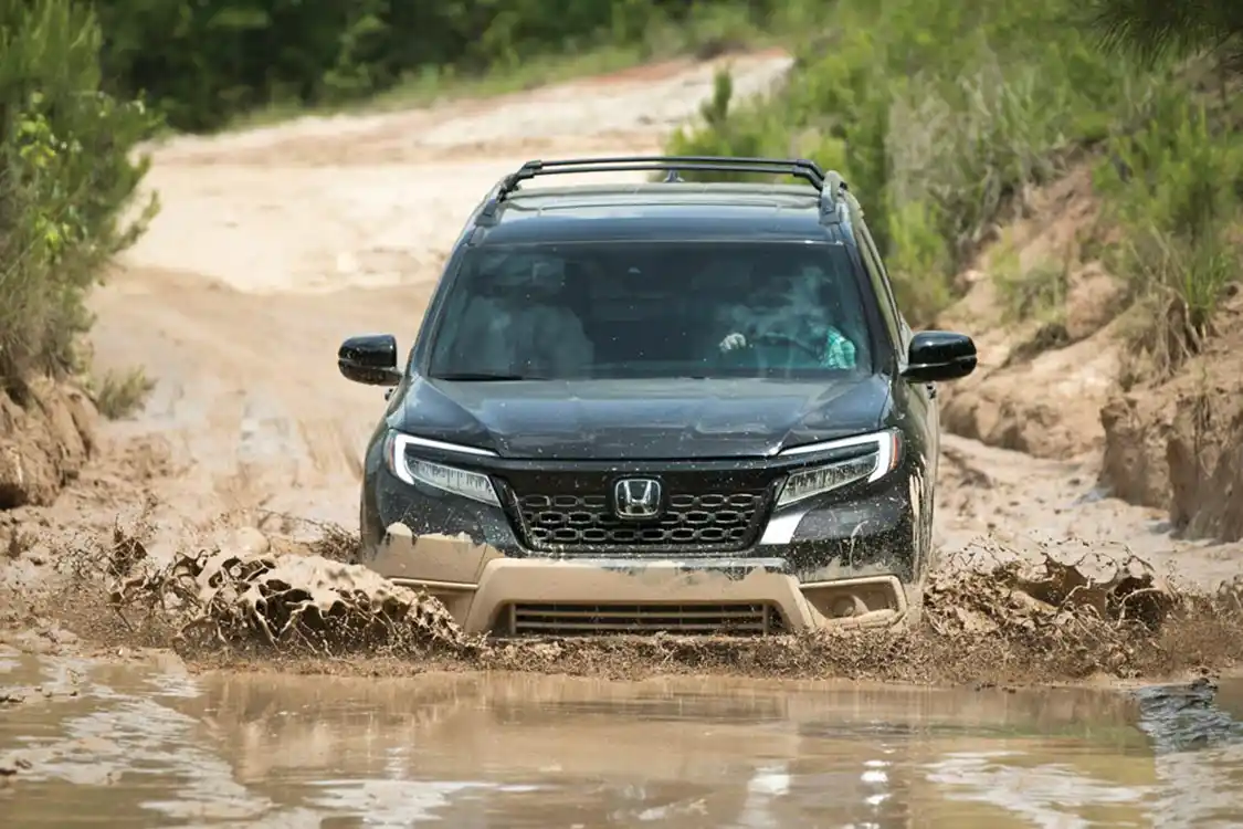 2019 Honda Passport Elite SUV driving into a muddy lake