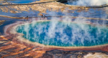 tourists walk along the grand prismatic spring of Yellowstone National Park