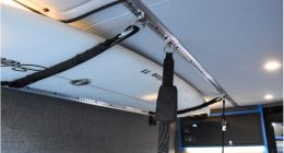 Straps used to secure a surfboard to roof of a van with Macs Tie Downs Versatie Track and Fittings.