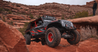 Jeep driving on red rocks in Moab, Utah.