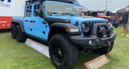 Light blue Jeep Gladiator with storage case mounted to roof.