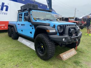 Light blue Jeep Gladiator with storage case mounted to roof.